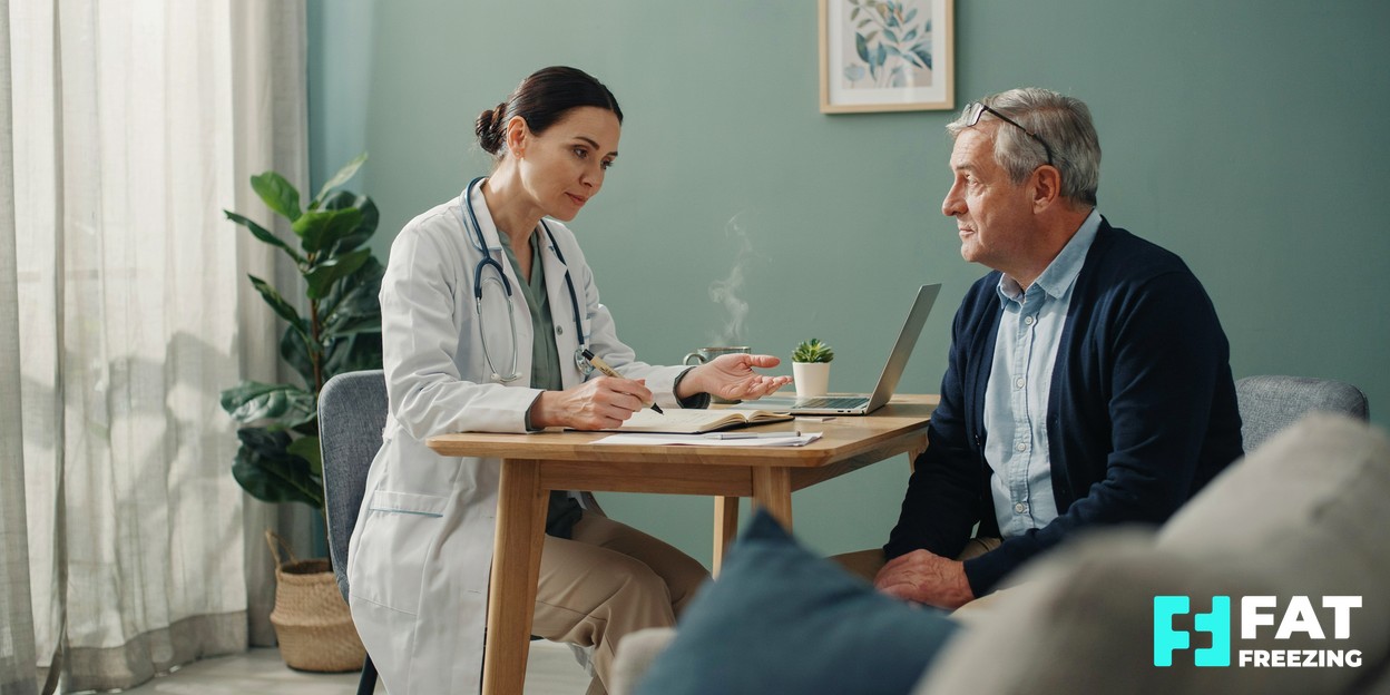 A clinician and patient sitting together at a desk in a bright modern consultation room, talking calmly over notes