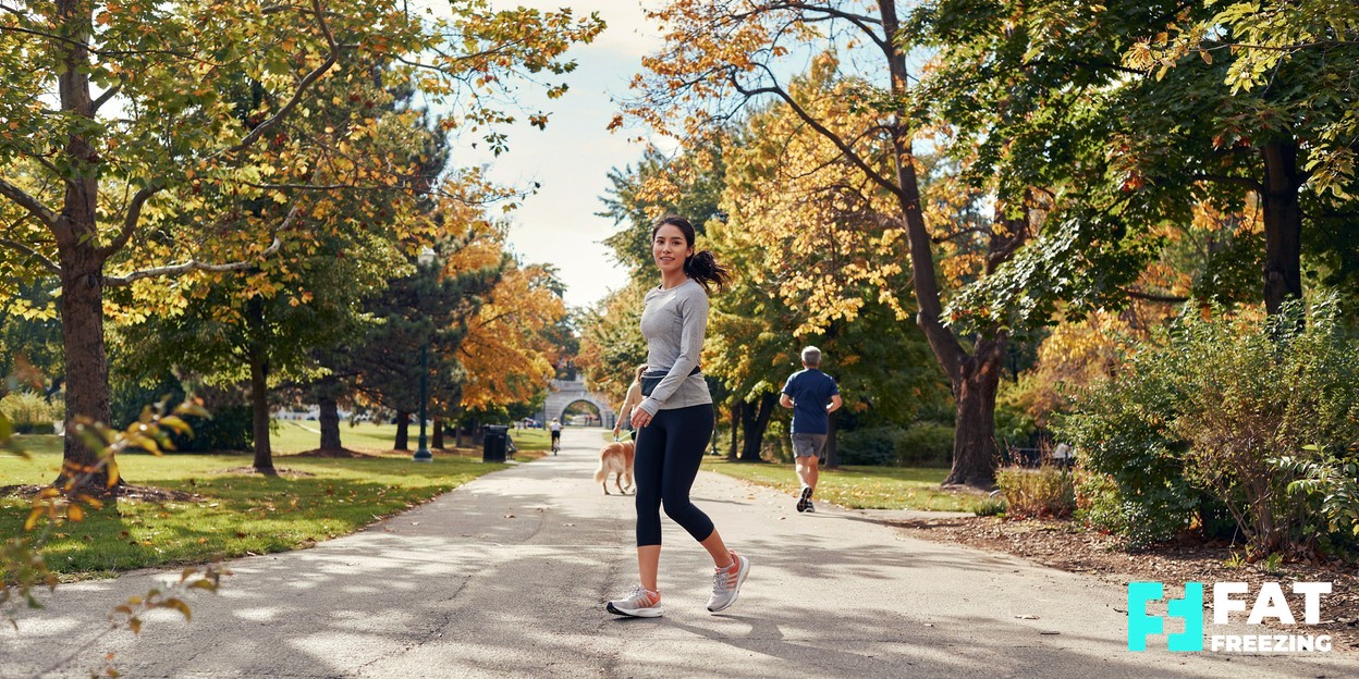 A person enjoying an active outdoor lifestyle, walking on a sunny tree-lined path, healthy and aspirational