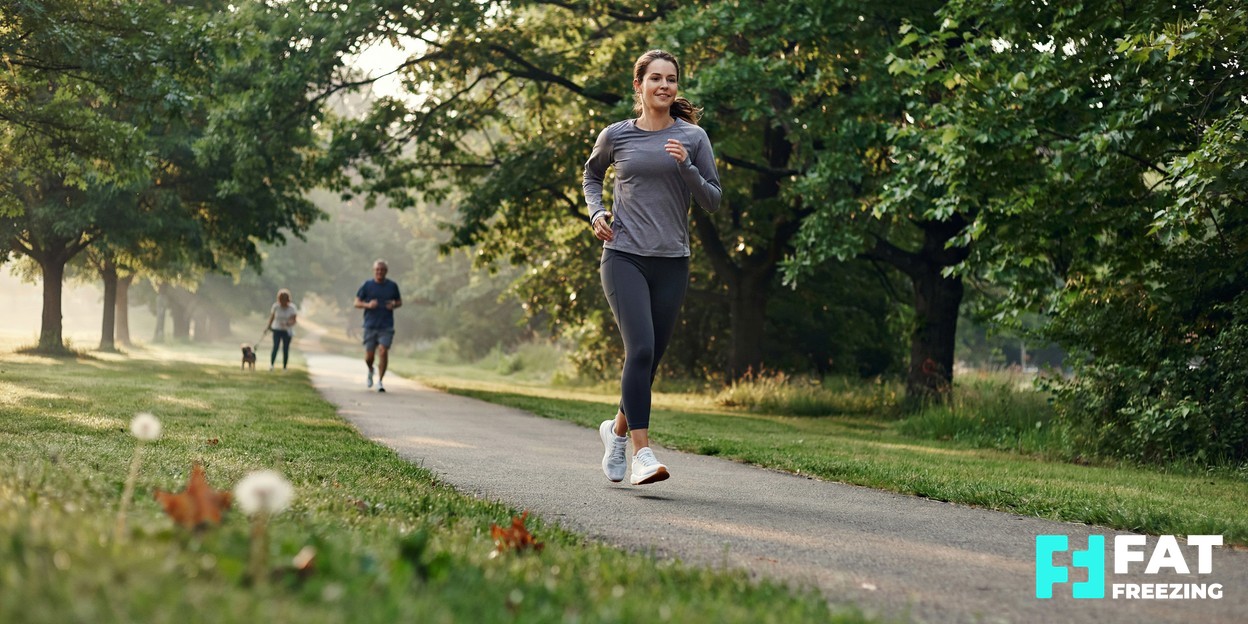 A person walking outdoors along a leafy path in comfortable activewear, relaxed and active in soft morning light