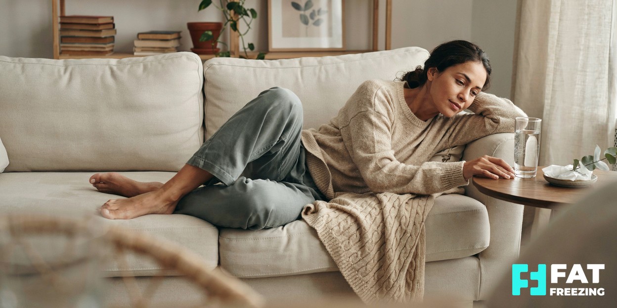 Person resting comfortably at home with a glass of water and warm light, recovering calmly after a treatment