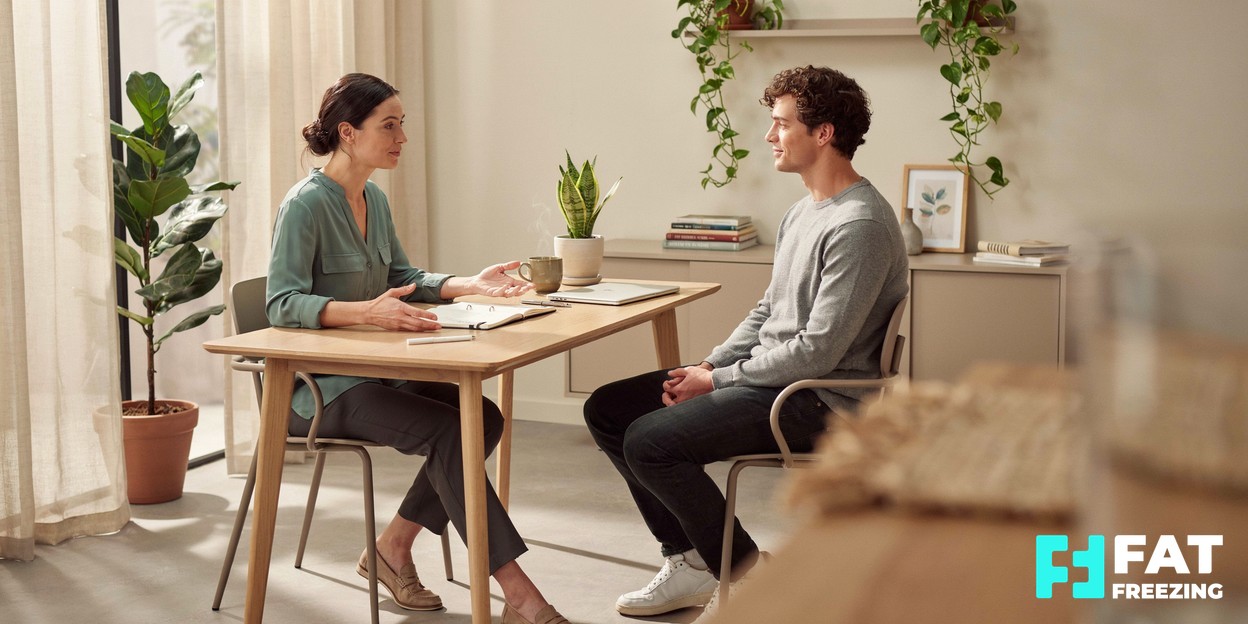 Practitioner and client talking through treatment options across a desk in a calm consultation room