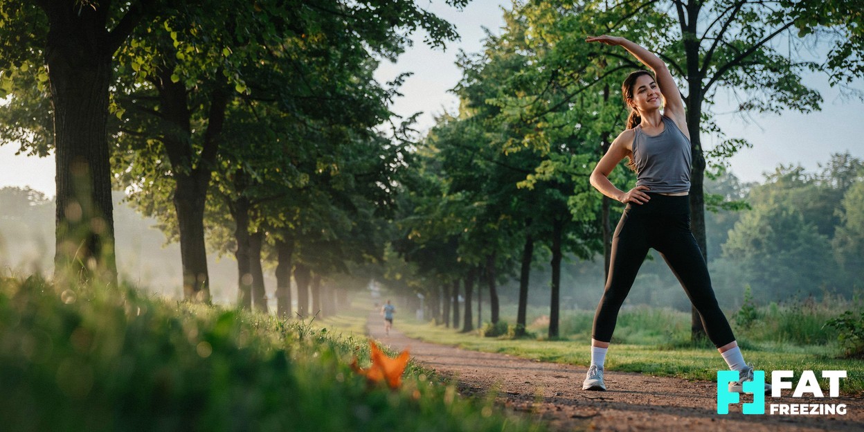 A person in athletic wear stretching outdoors in soft morning light, conveying a calm, healthy lifestyle