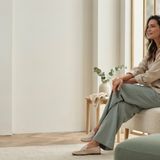 A calm, modern aesthetics clinic with soft natural light and a relaxed person looking thoughtfully out of a window