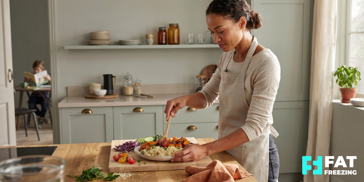 A person preparing a fresh, colourful healthy meal in a sunlit kitchen, conveying a balanced everyday lifestyle
