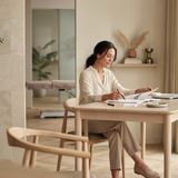 A bright, modern aesthetics clinic consultation room with soft natural light and a researcher reviewing notes at a clean desk